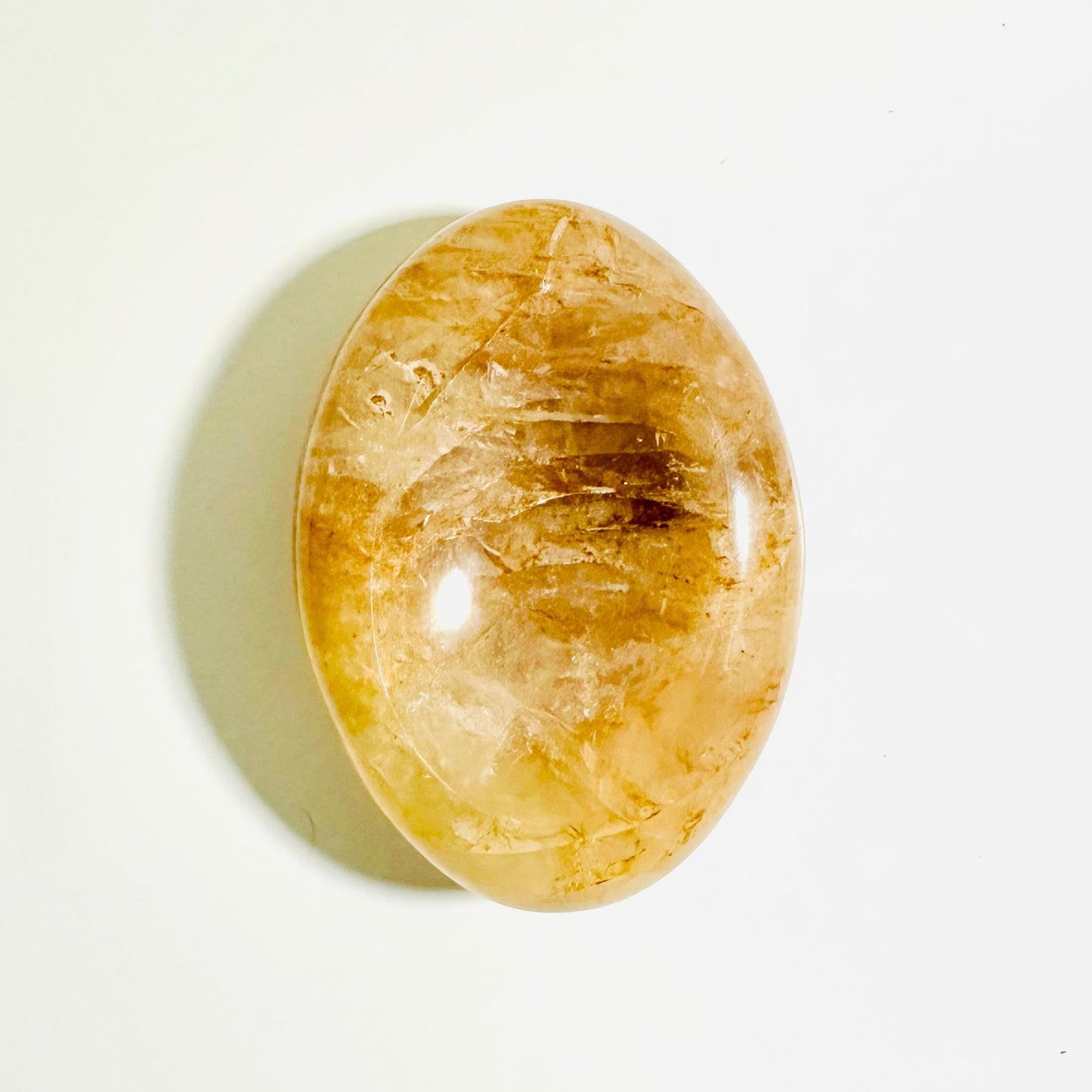 Oval-shaped yellow stone on a white background
