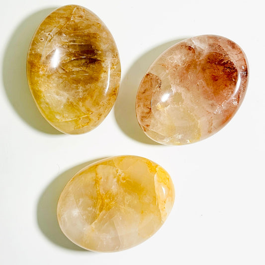 Three oval-shaped stones with different color patterns on a white background