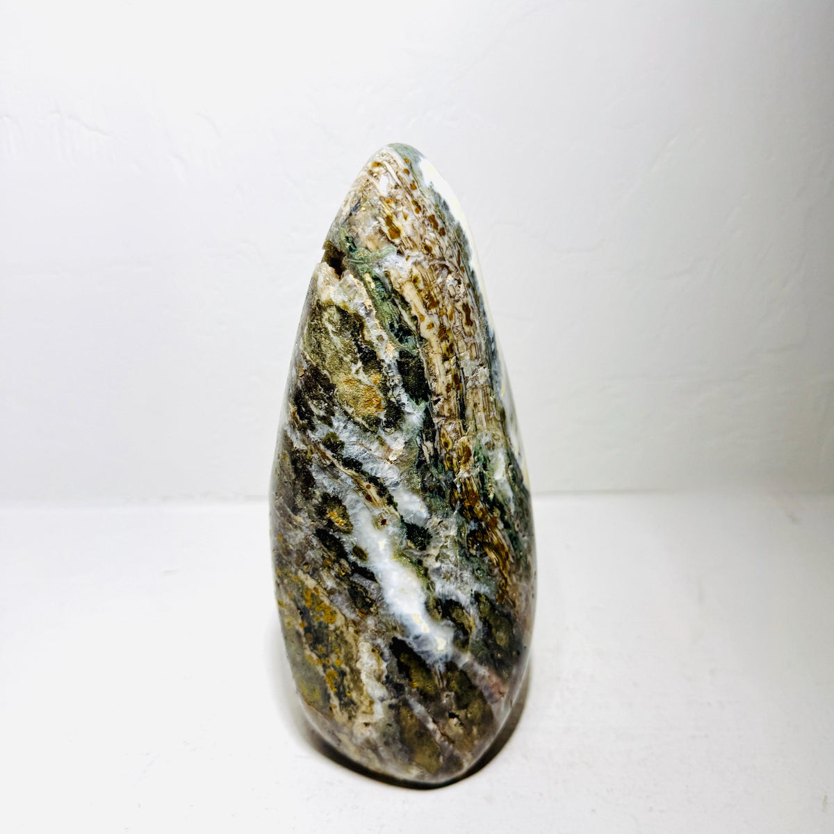 Side view of Ocean Jasper AE114 showing tapered shape, green bands, and textured pockets