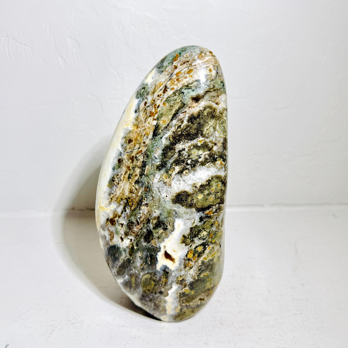 Reverse of Ocean Jasper AE114 showing mottled green mineral patterns and natural cavities