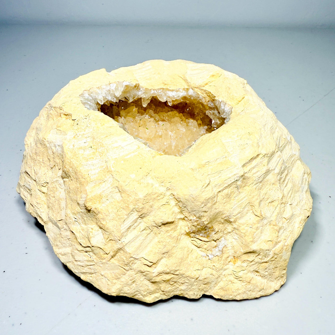 Quartz geode with rounded druzy cavity and cream matrix, front view