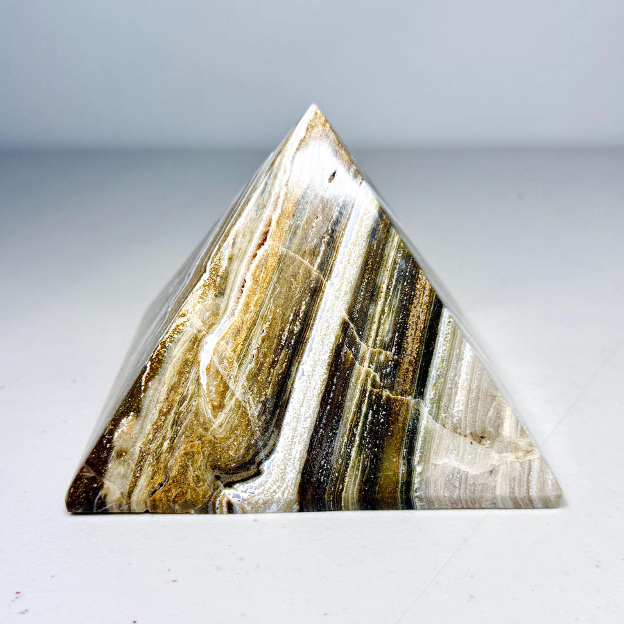 Ribbon jasper pyramid with cream, gold-brown and dark layered bands