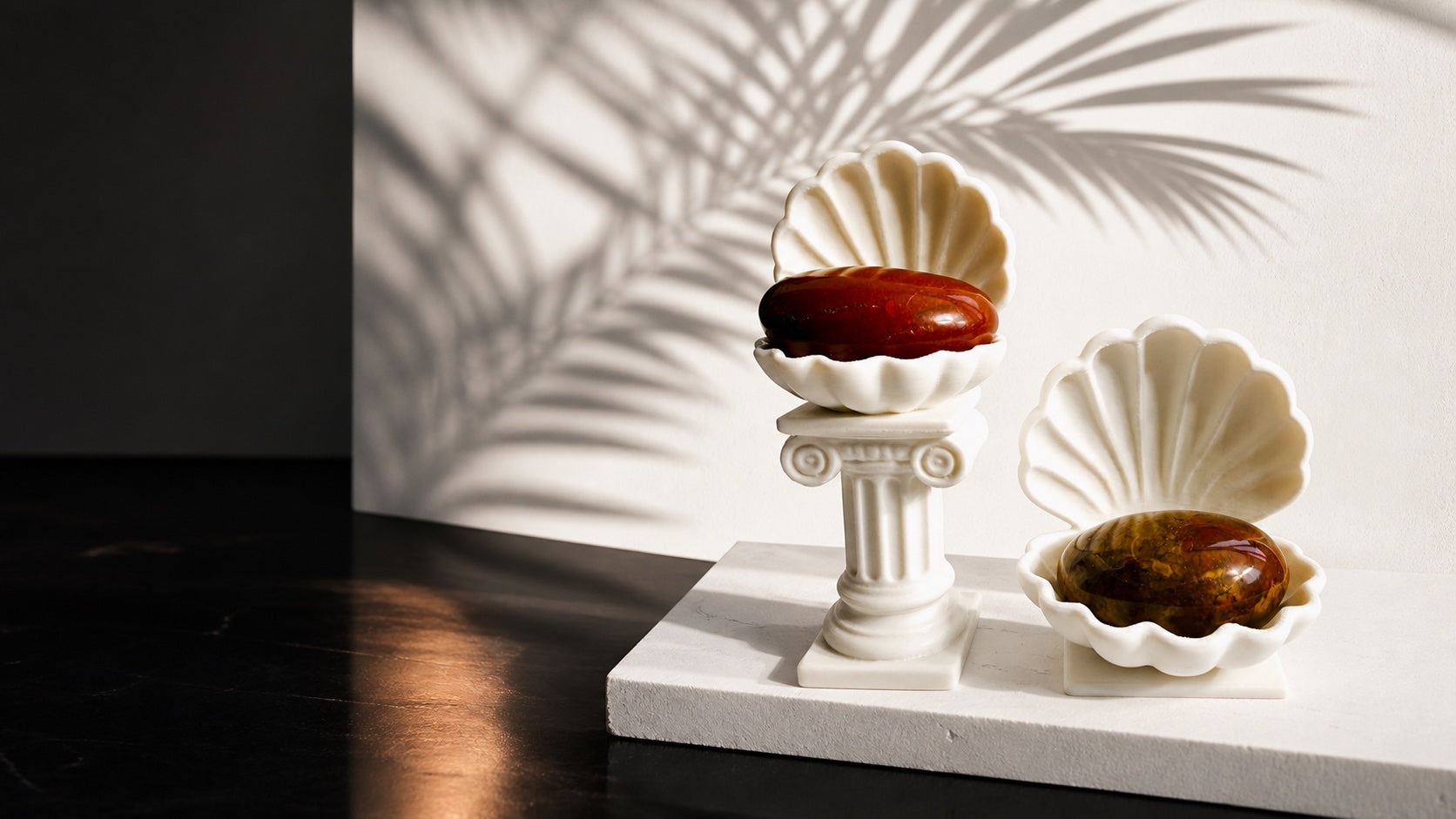 White KREATEUR Studio Venus clam shell crystal holders with amber palm stones in a tropical modernist setting