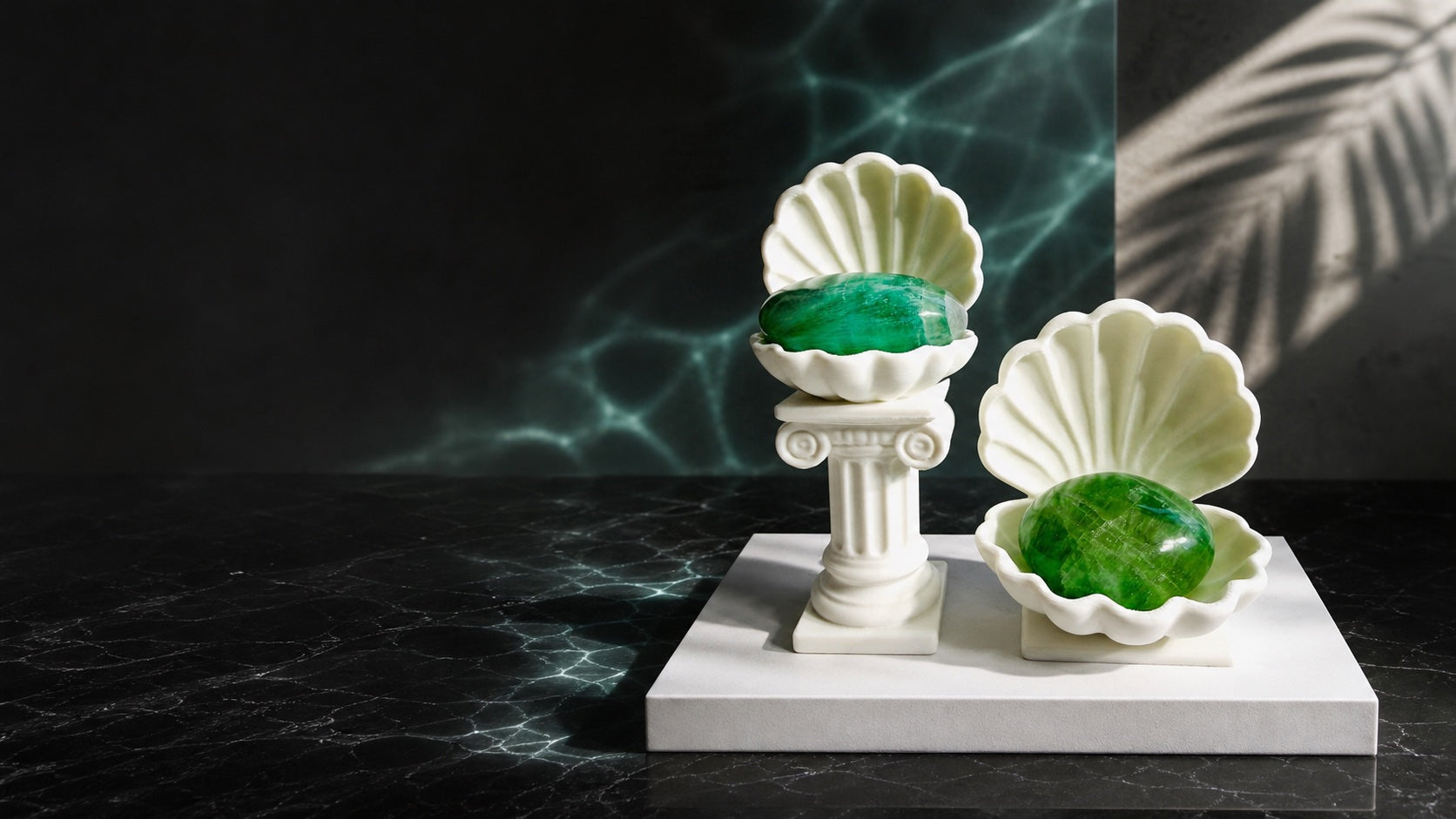 White KREATEUR Studio Venus clam shell crystal holders with green palm stones in a tropical modernist setting