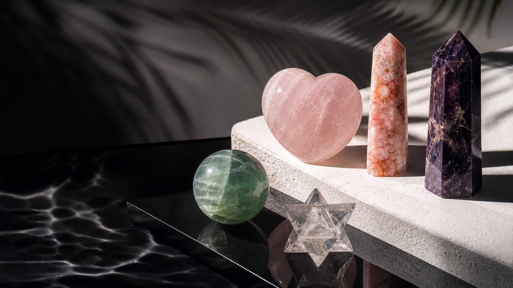 Rose quartz heart, clear quartz merkaba, fluorite sphere, and polished crystal towers in a KREATEUR editorial still life
